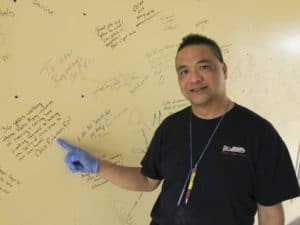 Rowell Bulson, a mover, shows some of the sentiments scribbled by St Joe's employees on a wall in the old hospital building. Bulson is one of an army of workers helping with the decommissioning of the 141-year-old hospital