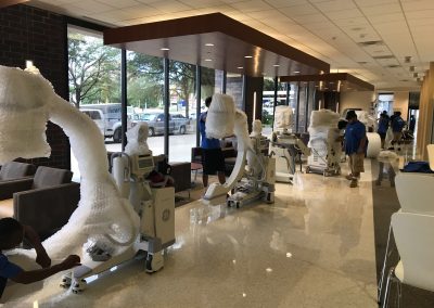 Several wrapped C-Arm scanners lined up in a hospital entry way.