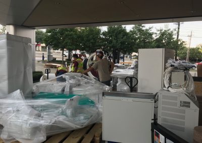 Men preparing large pieces of medical equipment for shipping.